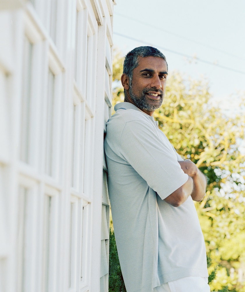 Man leaning against white wall in warm weather