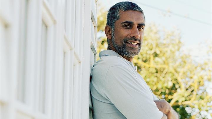 Man leaning against white wall in warm weather